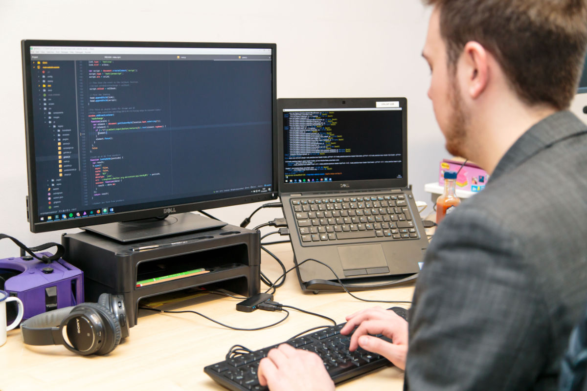 A Shelter web developer looking at code on a computer screen.